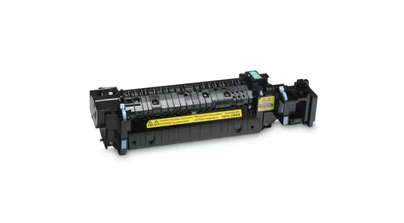 Technician inspecting a printer fuser unit for repair or replacement during maintenance.