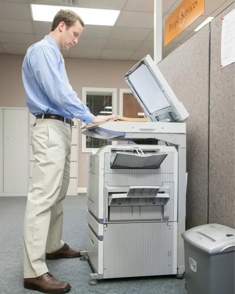 Employees using a multifunction photocopier for printing and scanning