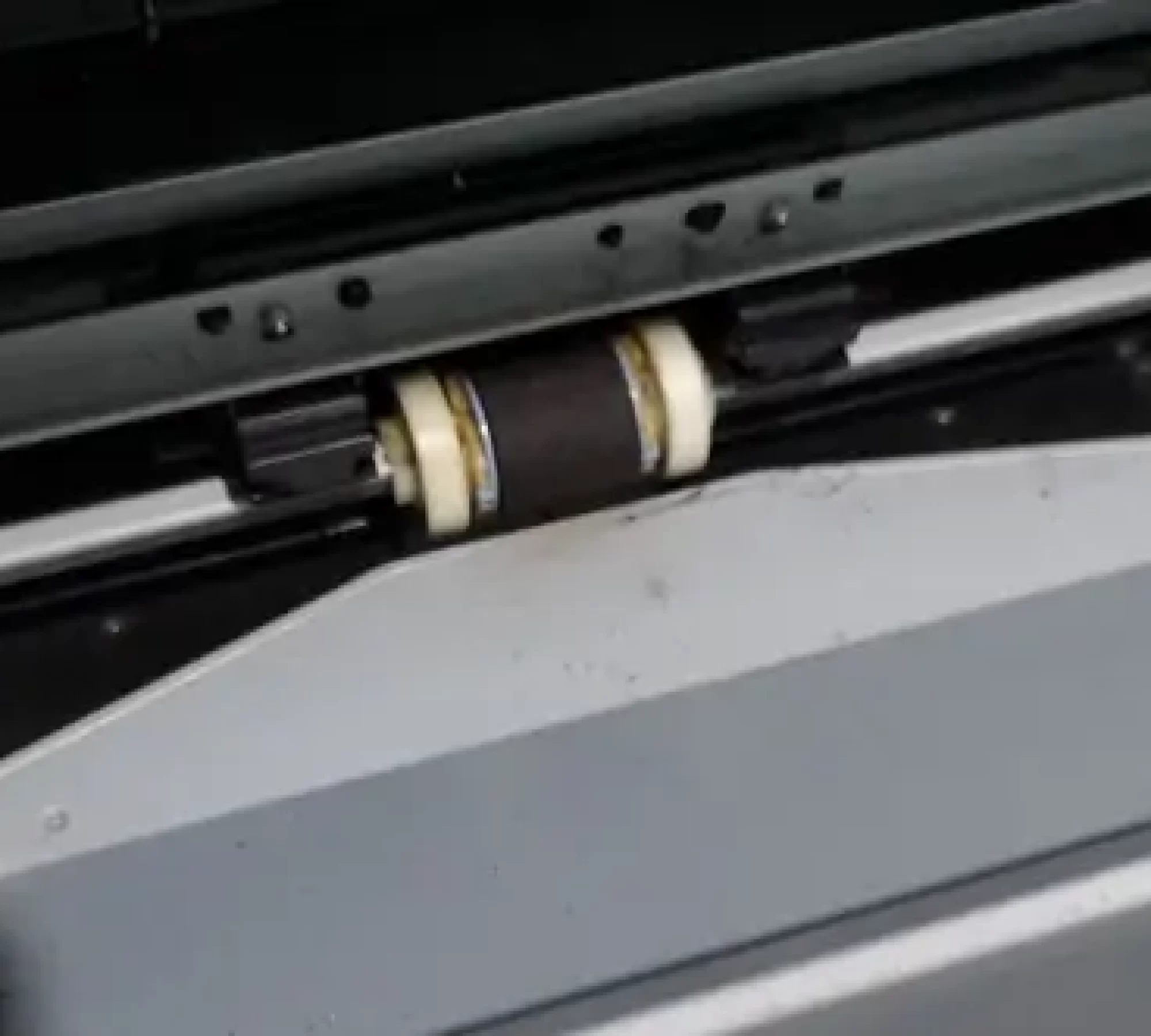 Close-up of printer rollers inside a laser printer showing the paper feed mechanism.